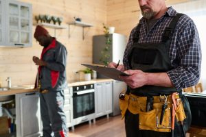 Two workers checking a modern kitchen installation.