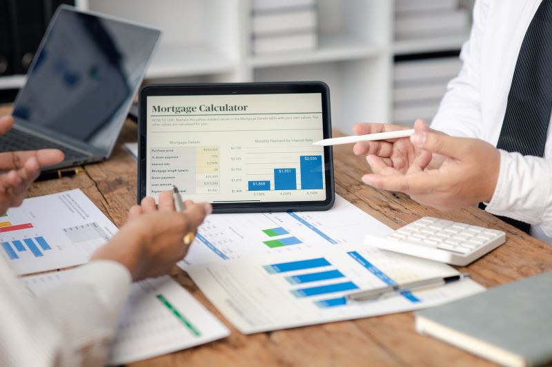 Team discussing mortgage calculator results on tablet.