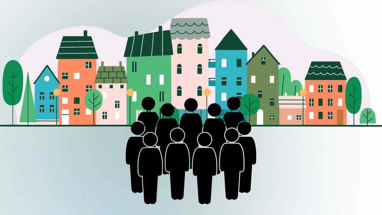 Silhouetted crowd in front of colourful buildings.